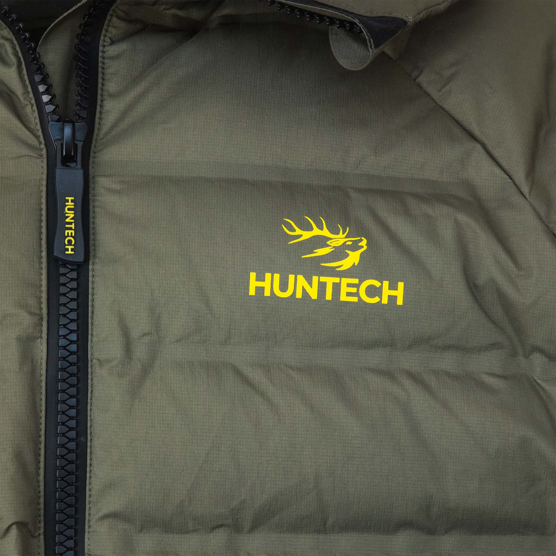 Close up of the Huntech logo on the left breast with the front zipper to one side.