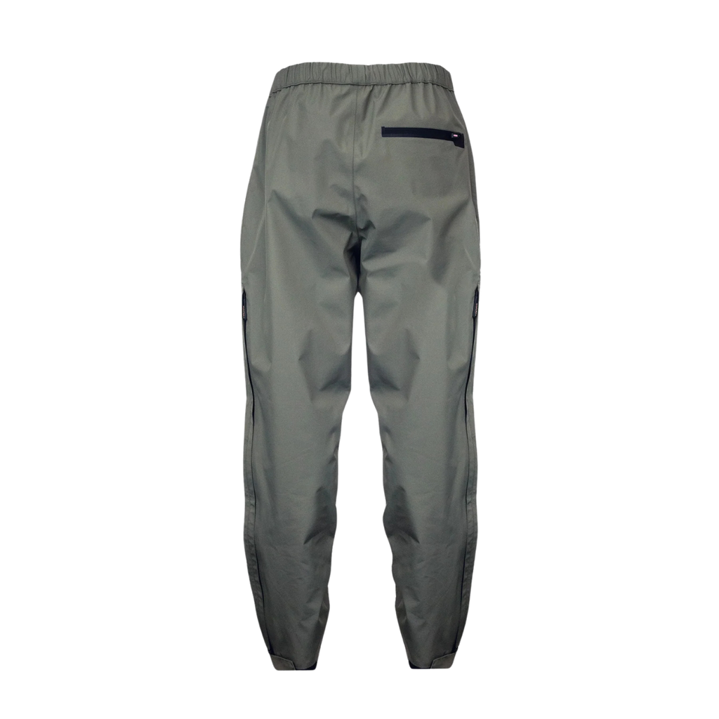 Back view of women’s waterproof pants with back zippered pocket on the right, an elastic waistband and adjustable hems. They ship from Australia and are shown here in a dark olive green/grey.