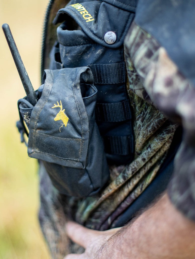 Close up of a Huntech branded butcher coat with a molle GPS pouch strapped to left chest pocket. Shown in XXX, this coat ships from Australia.