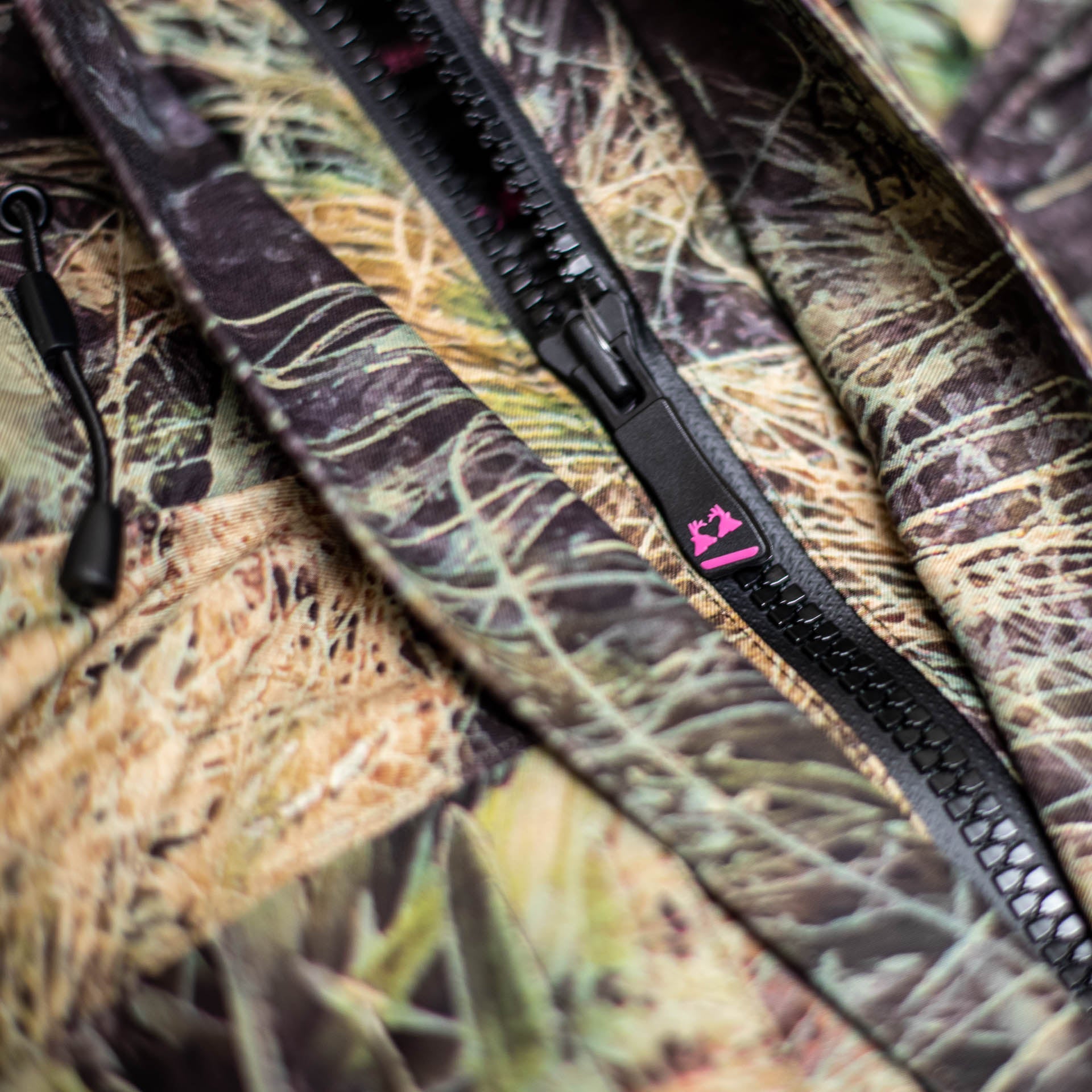 Close up of the zipper with the twin stag head logo in pink on the pull tab.