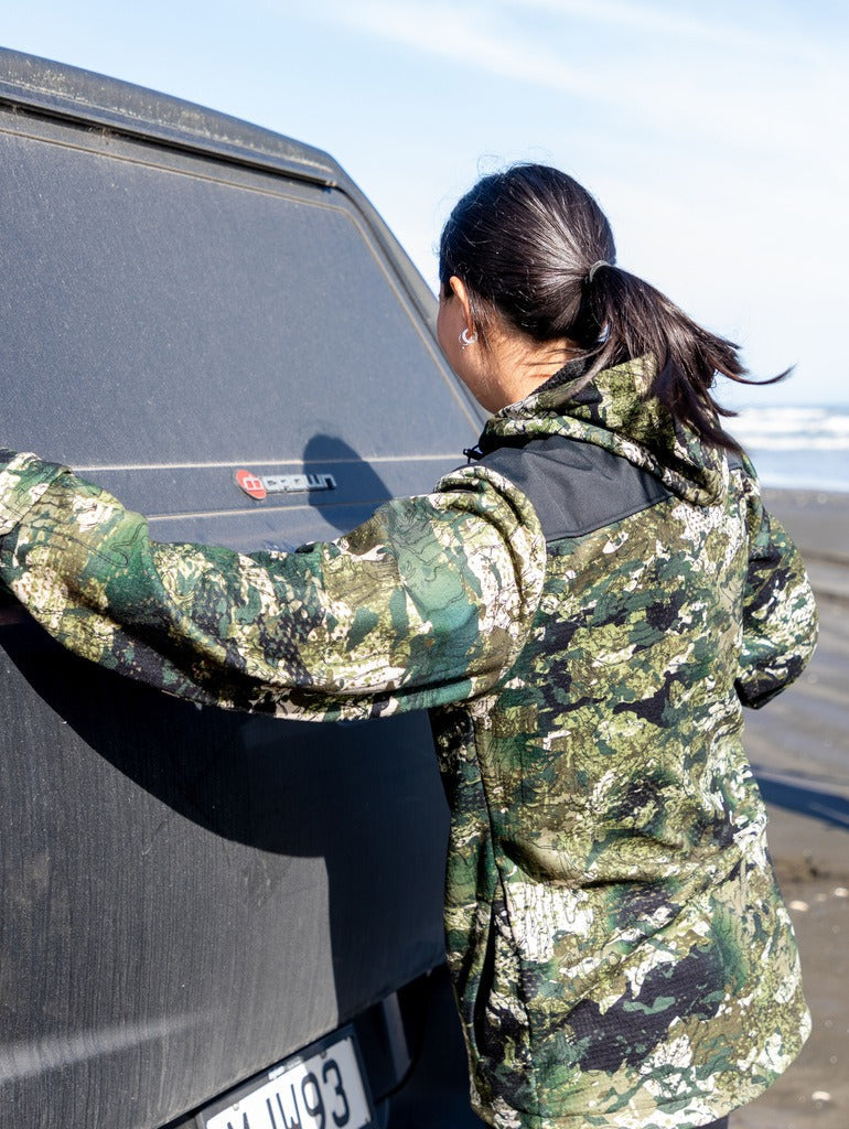 Image of woman wearing a coat in the kakariki camo pattern.