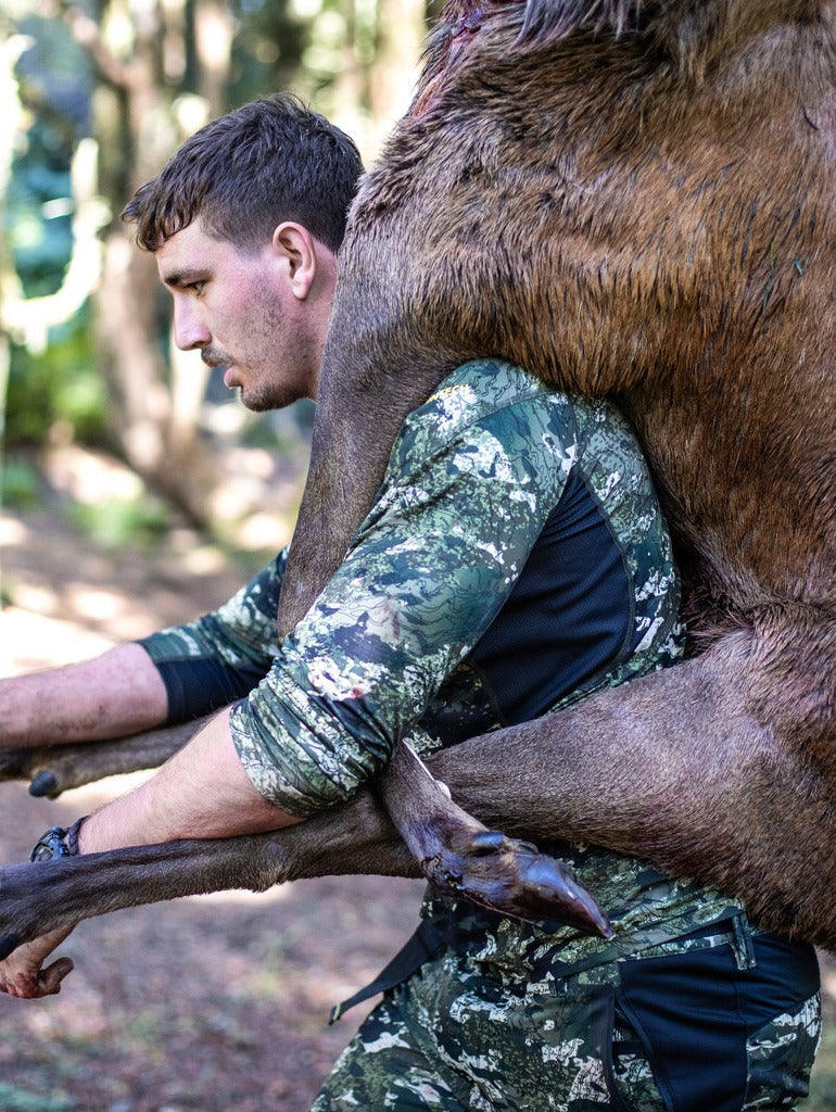 Hunter shown wearing kakariki pattern with pig slung over shoulders.