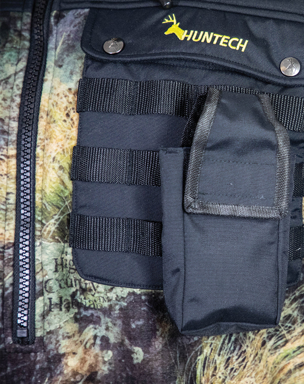 Close up of a Huntech branded butcher coat with a molle GPS pouch strapped to left chest pocket. Shown in XXX, this coat ships from Australia.