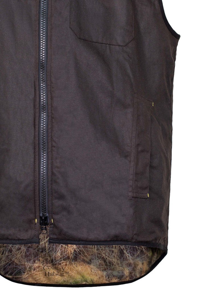 Close up of lower edge of the vest, with side pocket showing. Vest is shown zipped up.