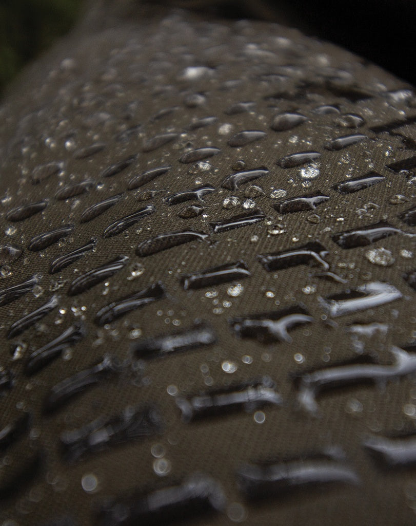 Close up of water beading on the surface of material coated in military-grade repellent to help repel water, blood, mud, ice, oil and other liquids.