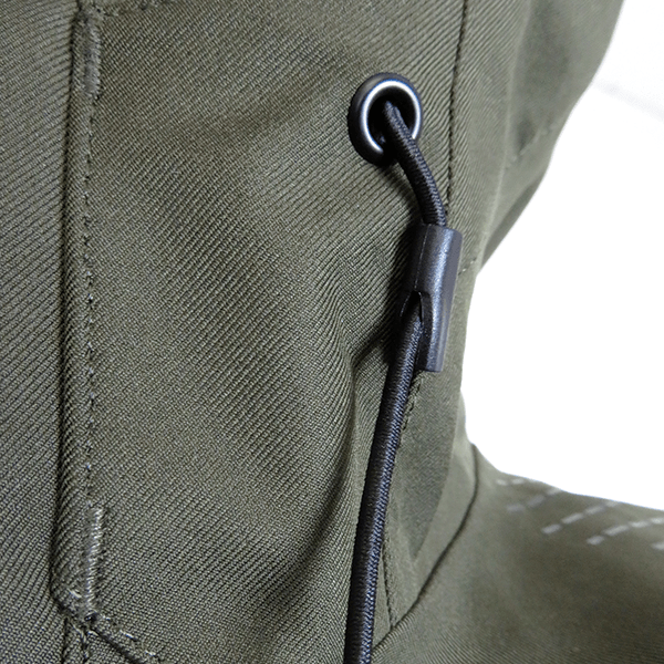 Close up of cinch cord designed to have the hood sitting close to the head. Jacket is in military green.